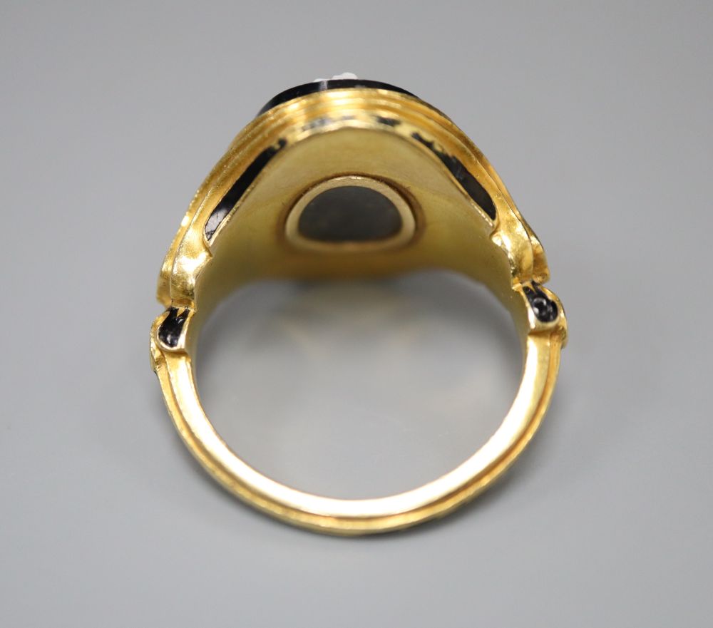 A Victorian 18ct gold cameo ring, of carved scrolled design with black enamelled decoration and hairwork panel, size M/N,